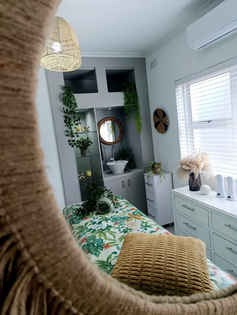 Modern beauty treatment room featuring a massage table, natural textures, and stylish accessories.