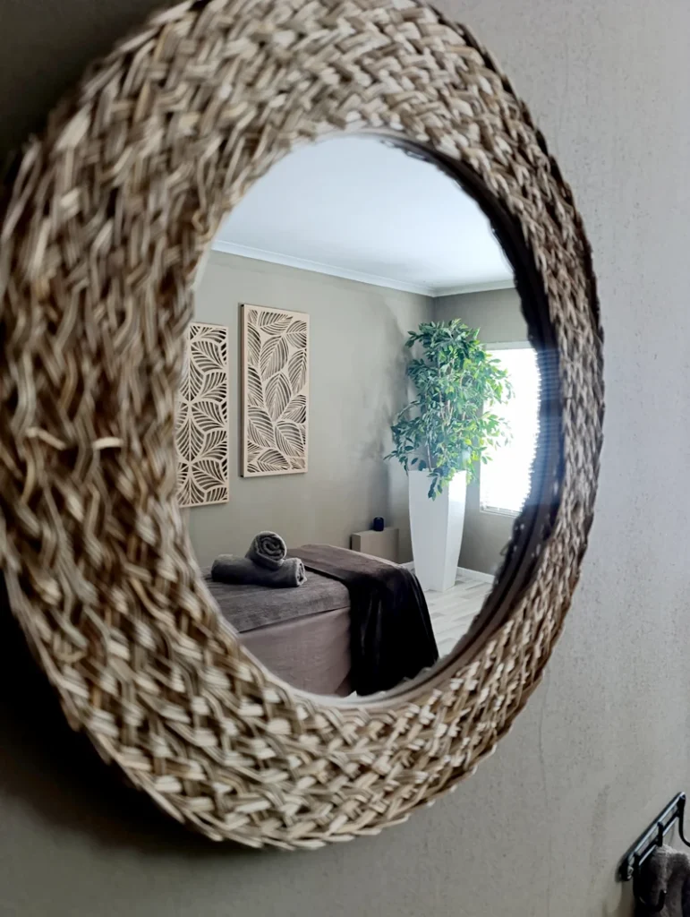 Woven mirror reflecting calming massage space at Absolute Beauty, Brackenfell – perfect for hot stone and full-body massages.